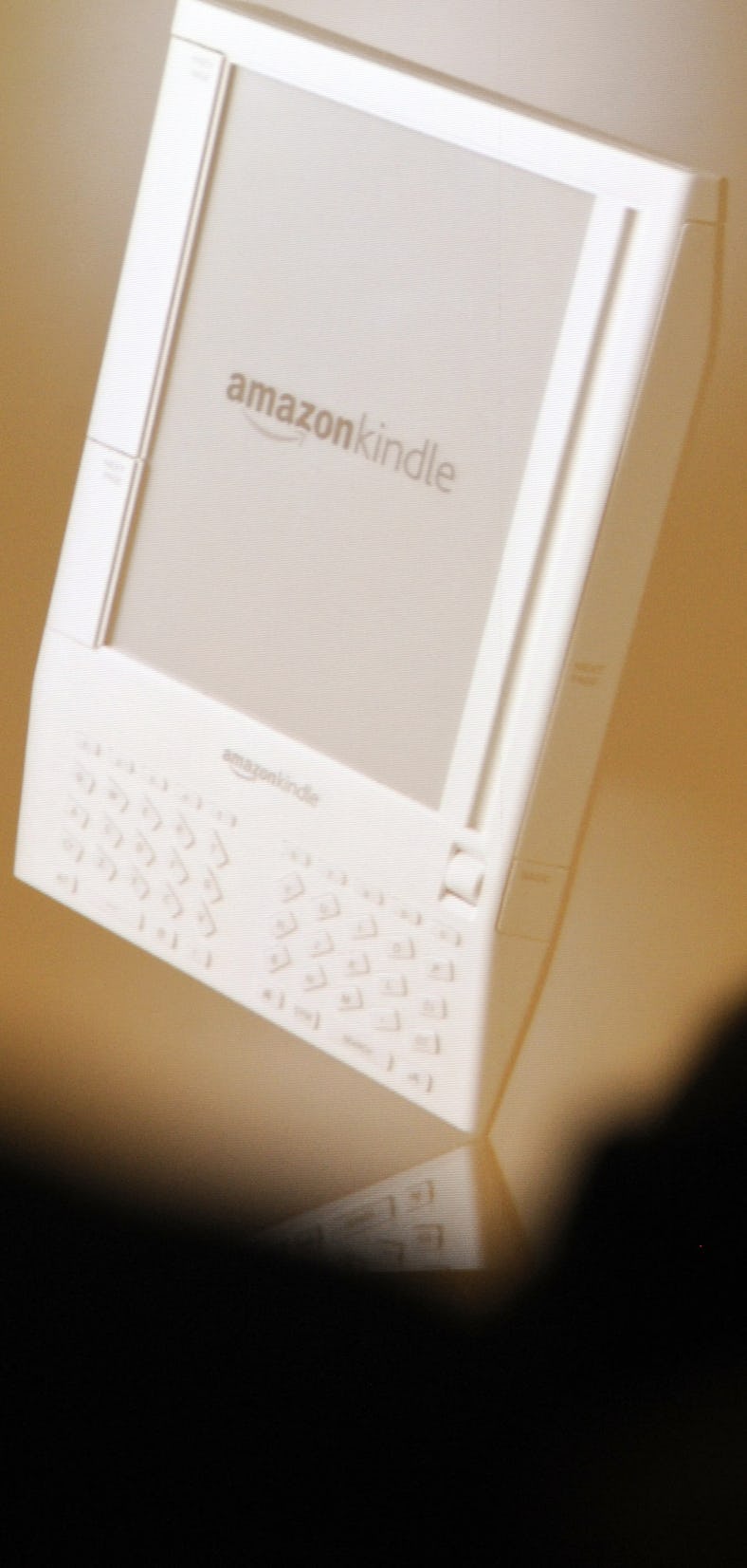 Visitors attend a presentation of Amazon's new e-reader device "Kindle" at the Frankfurt Book Fair O...