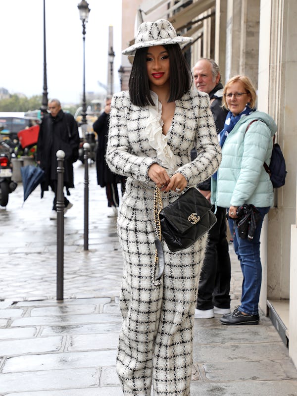 Cardi B wears a black-and-white tweed suit with a Chanel 19 bag.
