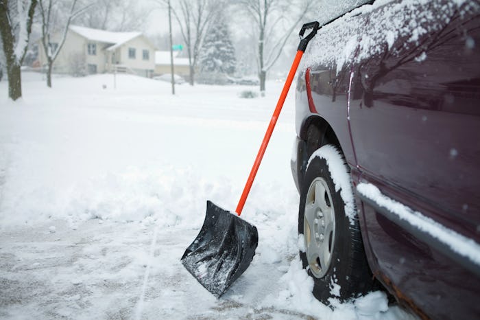 A snow shovel leaning against a car, in a story answering the question, can you shovel snow while pr...