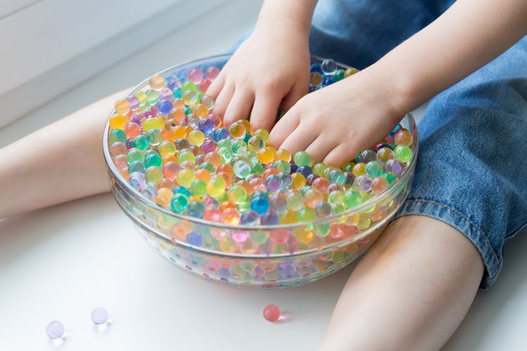 A child plays with hydrogel water beads. Rainbow hydro balls Orbeez