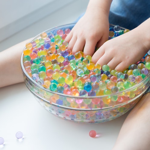 A child plays with hydrogel water beads. Rainbow hydro balls Orbeez