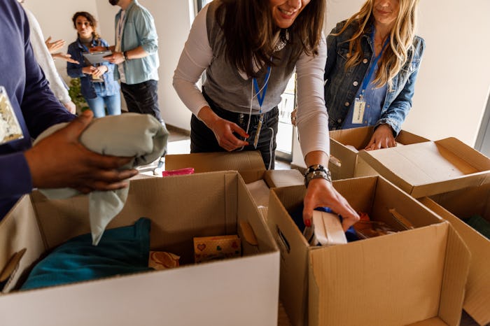 Close up shot of diverse group of people volunteering at the volunteer center. They are working as a...