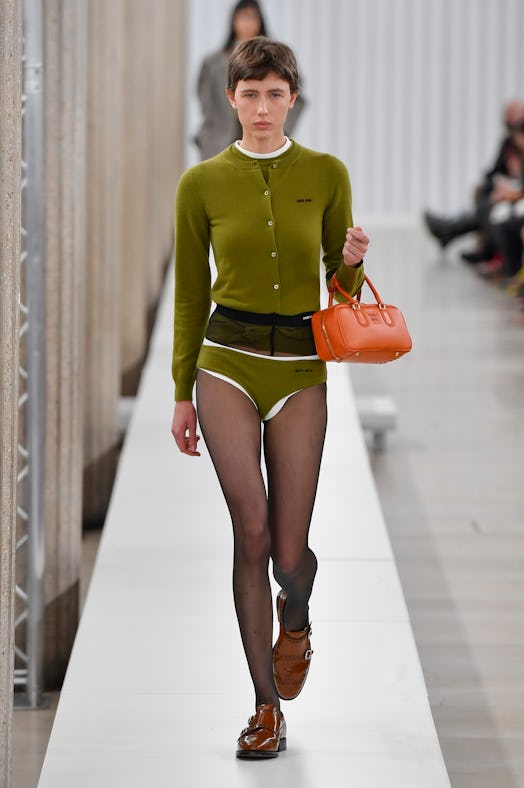 a model walks the runway during the Miu Miu Womenswear Fall Winter 2023-2024 in green underwear and …