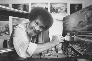 TV painting instructor/artist Bob Ross using a large paint brush to touch up one of his large seasca...