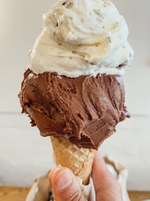 A double scoop gelato of vanilla choc chip and chocolate in a hot spring day.