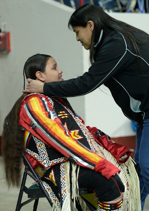 American Indian woman braiding her son's hair in Denver 2015