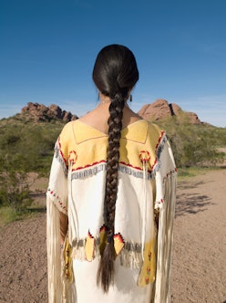 Native American woman with long braid and ringed jacket