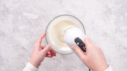 Flat lay. Step by step. Mixing ingredients in a glass mixing bowl to prepare cream cheese frosting.