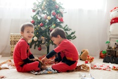 Two adorable boys, opening presents to share on Christmas at home
