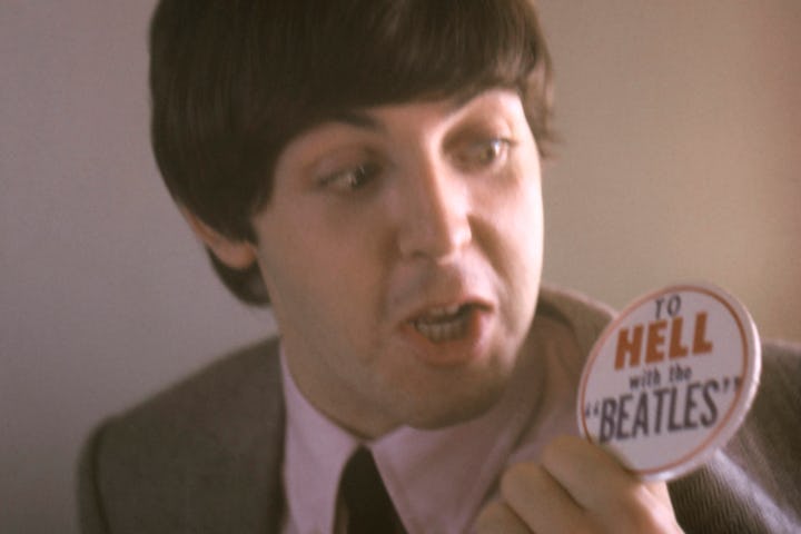 Paul McCartney looking at a badge saying "To Hell with The Beatles", circa 1966. (Photo by Screen Ar...