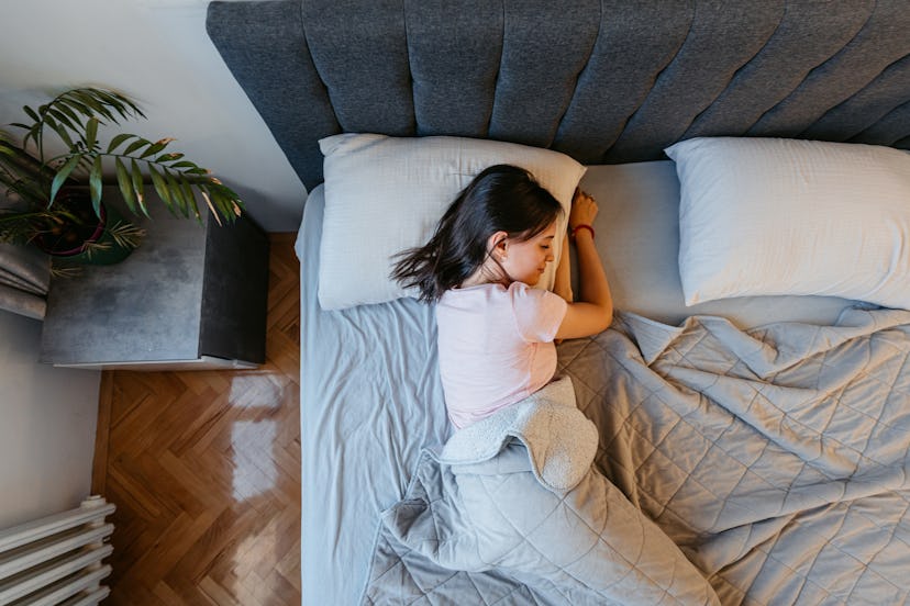 Beautiful young woman sleeping on the bed in the morning in her bedroom.