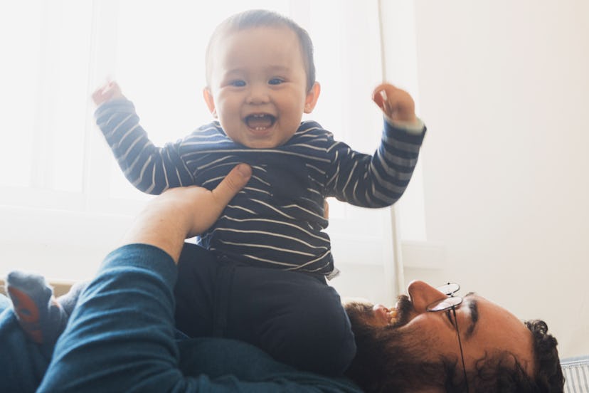 Baby laughs happily while sitting on dad's chest, in a story answering the question "why does my bab...