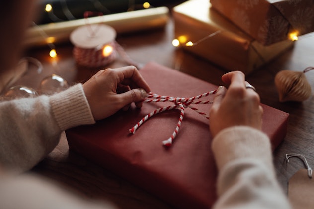 Close-up of female hand tying a bow on Christmas gift