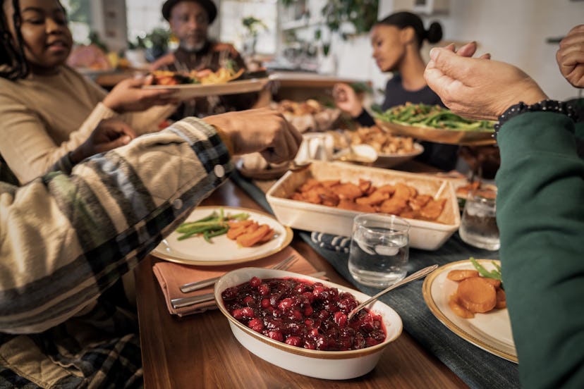 Family passes Thanksgiving dishes around the table, in a story about helping a picky kid enjoy Thank...
