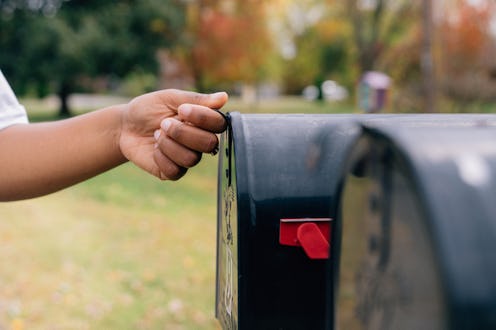 Part of a Series: African American / Black Woman Receiving a Mail-In Ballot to Vote from Home in the...