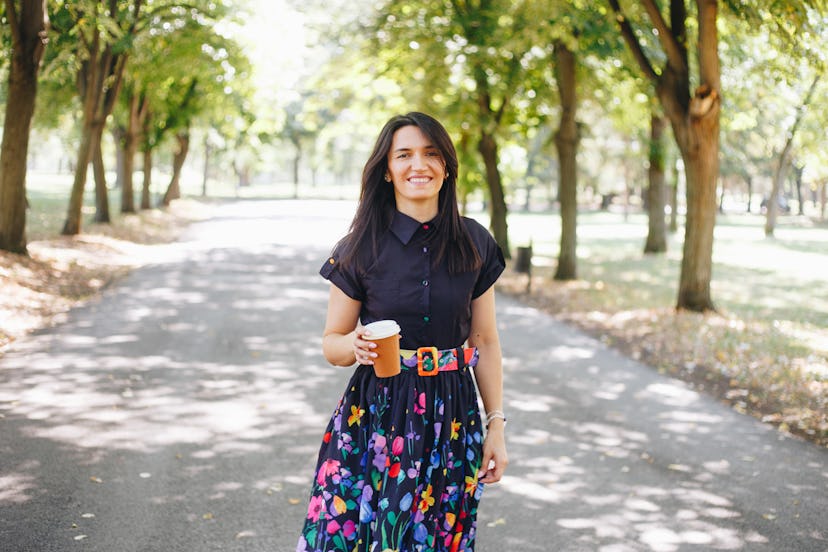 Woman smiling and drinking coffee to go stock photo