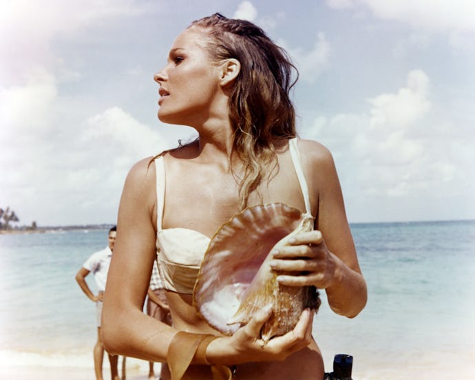 Ursula Andress, Swedish actress, wearing a white bikini and holding a conch shell in a publicity sti...
