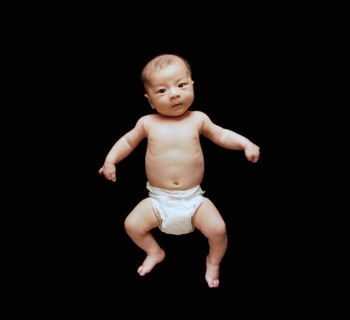 newborn baby on black backdrop in article about old wives tales about babies born on new year's janu...