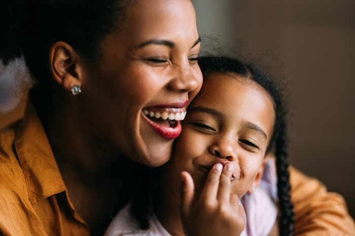 A portrait of an adorable Cuban child playing with her laughing mother.
