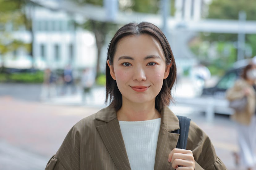 Asian Business Woman looking at camera In Outdoors,  Young woman on her morning commute.
Woman headi...