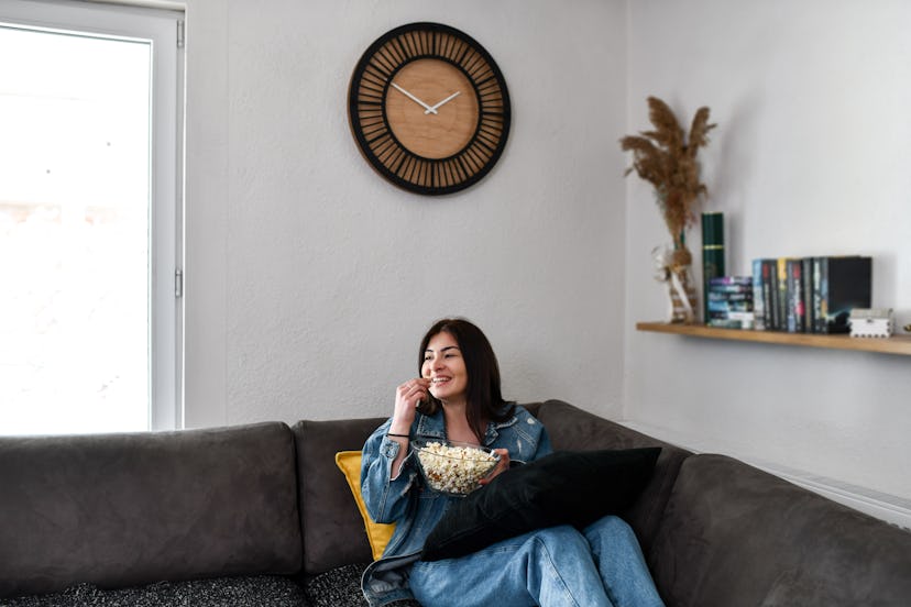 Beautiful Smiling Female Eating Popcorn While Watching TV