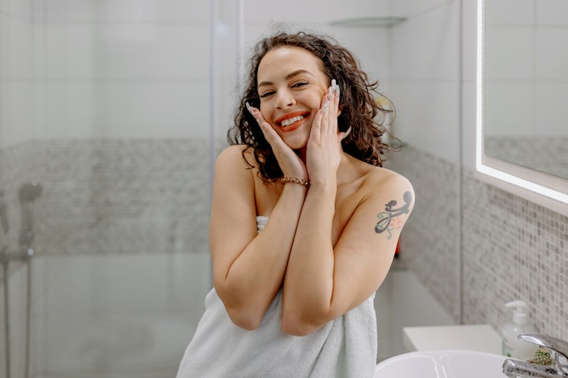 Adorable confident young Caucasian woman wearing towel feeling good in her skin