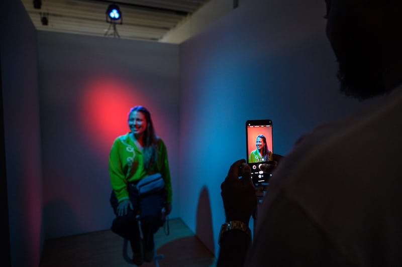 An attendee poses for a photo in a booth during a product launch event for the Google Pixel 8, and P...