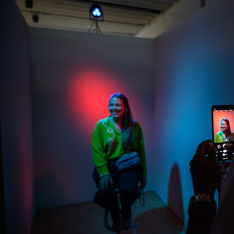 An attendee poses for a photo in a booth during a product launch event for the Google Pixel 8, and P...