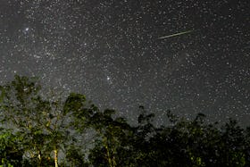 A green meteor is seen in the sky during the Geminid meteor showers in Ratnapura, Sri Lanka, on Dece...