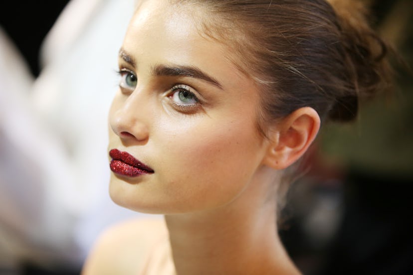 Taylor Hill wears glitter lips by makeup artist Pat McGrath backstage at Versace Atelier in 2016.