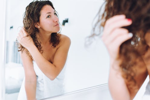 Curly hair confidence: woman analyzes and prepares her hair for a new day