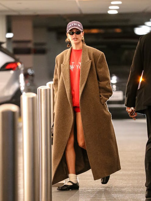 Hailey Bieber wore tiny red shorts with a dad hat on December 14, 2023.