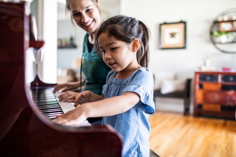Mother and daughter playing piano, music lessons would be a wonderful experience gift to ask for