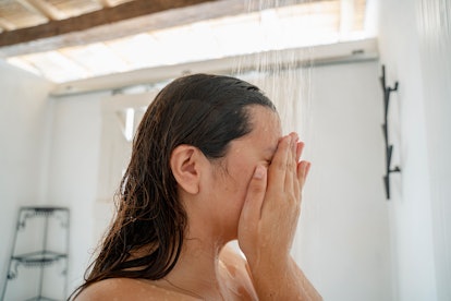 A young woman taking a shower in a hotel early morning