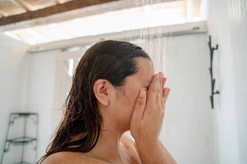 A young woman taking a shower in a hotel early morning