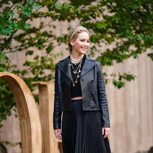 PARIS, FRANCE - SEPTEMBER 24: Jennifer Lawrence wears a black leather jacket, a golden necklace, a b...