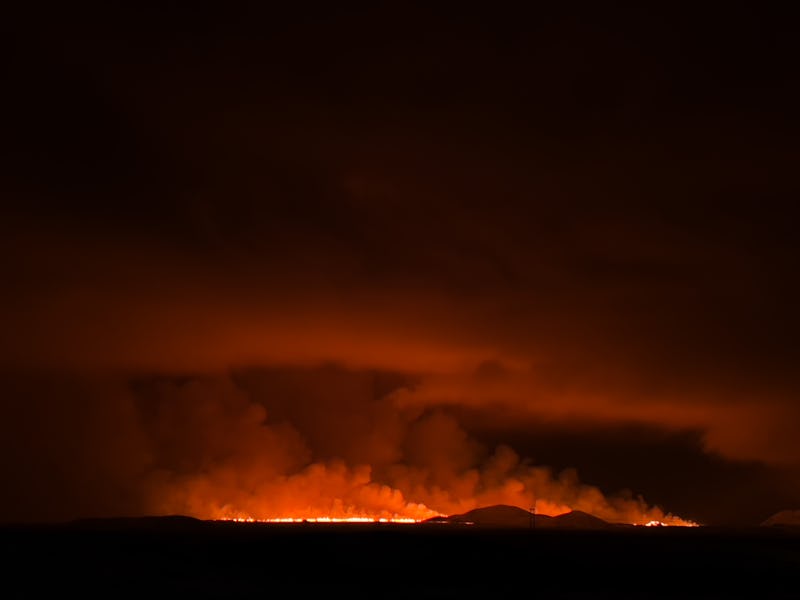 GRINDAVIK, ICELAND - DECEMBER 18: A volcano erupts on the Reykjanes Peninsula near the power station...