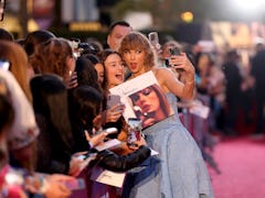 Taylor Swift takes a photo with Swifties at her movie premiere in Los Angeles.