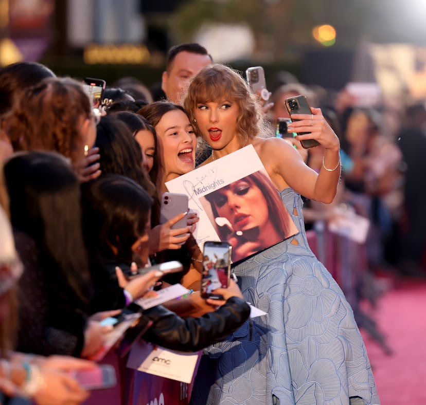 Taylor Swift takes a photo with Swifties at her movie premiere in Los Angeles.