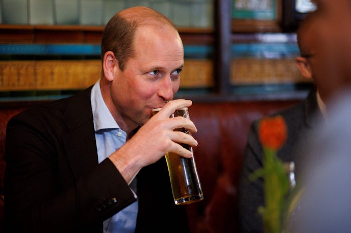 Britain's Prince William, Prince of Wales drinks a beer as he visits the Dog & Duck Pub in Soho, cen...