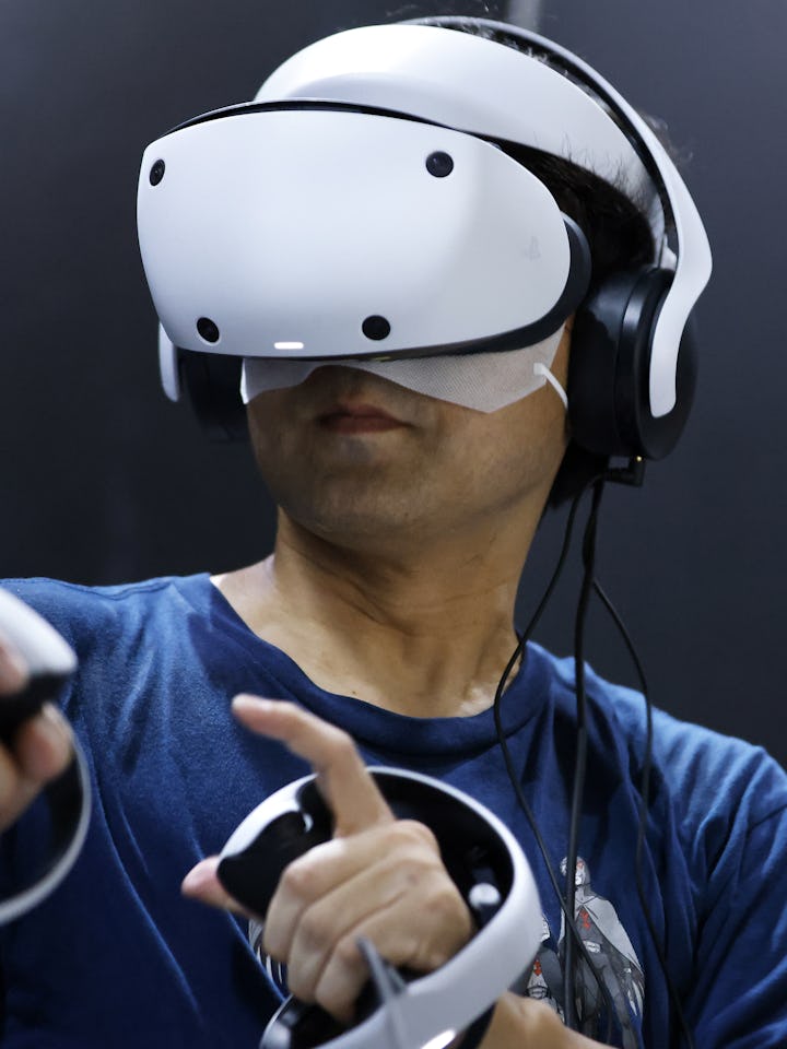 An attendee wears a Sony Group Corp. PlayStation VR2 (PS VR2) headset to play the Resident Evil 4: V...