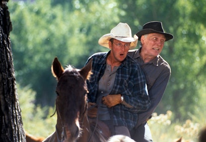 Daniel Stern and Jack Palance on the back of one horse together in a scene from the film 'City Slick...