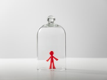 Plastic figure of a man under a glass cover - loneliness, depression, isolation concept