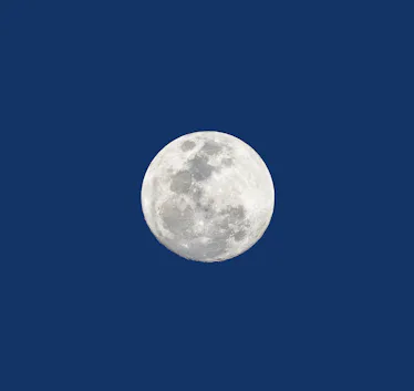The Moon is bright. The bottom edge has ridges and textures that come out against the backdrop.