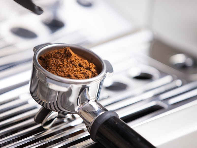 freshly ground coffee beans in a portafilter by the coffee grinderfreshly ground coffee beans in a p...