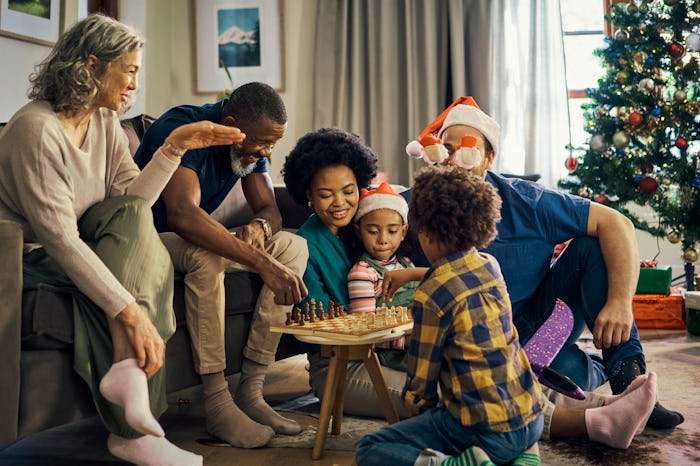 Family, Christmas and celebrate holiday with chess, grandparents and parents with children at family...