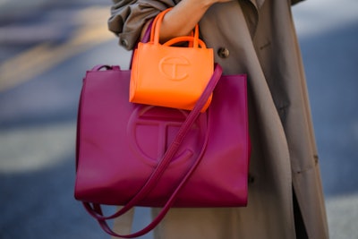 NEW YORK, NEW YORK - SEPTEMBER 14: Samia Laaboudi wears a beige long trench coat, a neon orange shin...