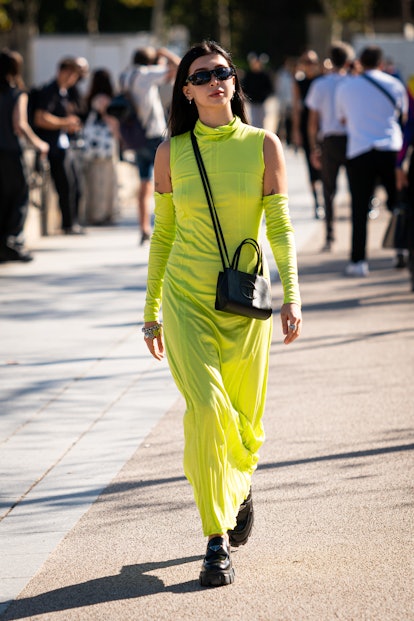 PARIS, FRANCE - OCTOBER 01: A guest wears a lime green maxi dress, Telfar crossbody bag and Prada lo...