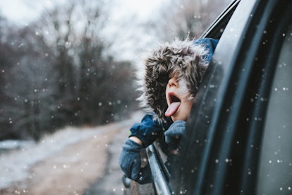 instagram captions for christmas road trip; boy catches snowflakes from car window