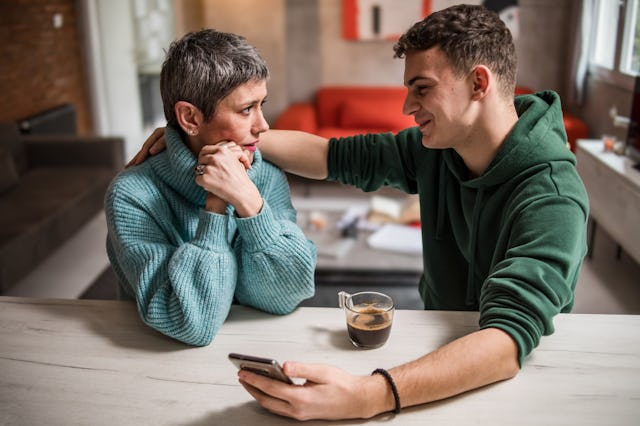 A mother and son are sitting at home and talking, helping her son solve his teenage problems